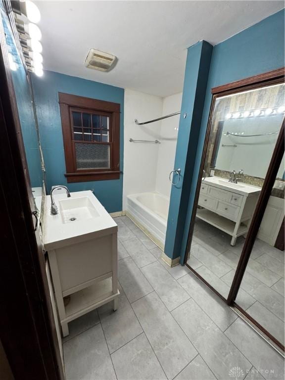 bathroom with vanity, tile patterned flooring, and a bathtub