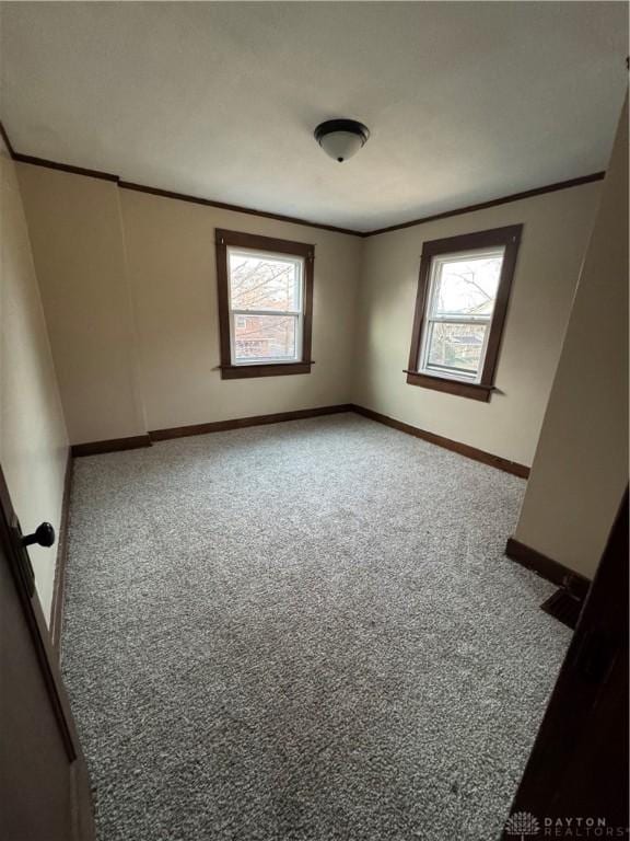 carpeted spare room with crown molding