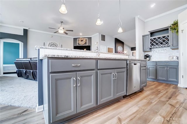 kitchen with gray cabinetry, tasteful backsplash, decorative light fixtures, light hardwood / wood-style flooring, and a kitchen island