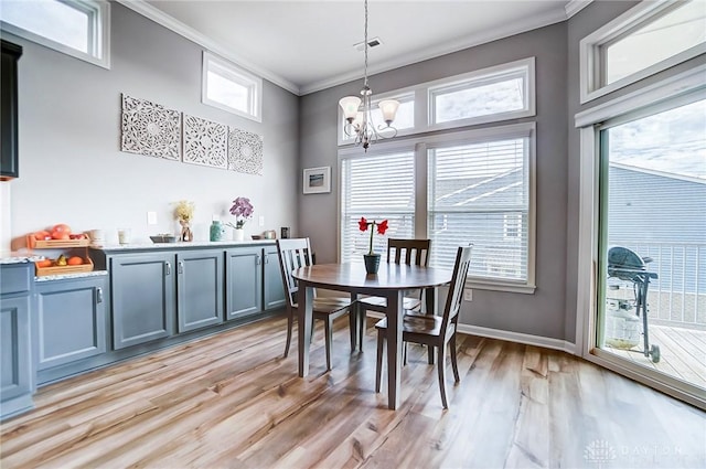 dining room with crown molding, light hardwood / wood-style floors, and a healthy amount of sunlight