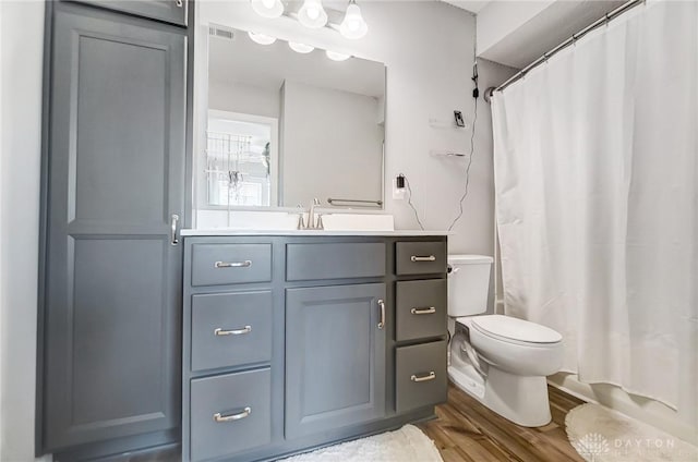 bathroom with vanity, wood-type flooring, toilet, and walk in shower