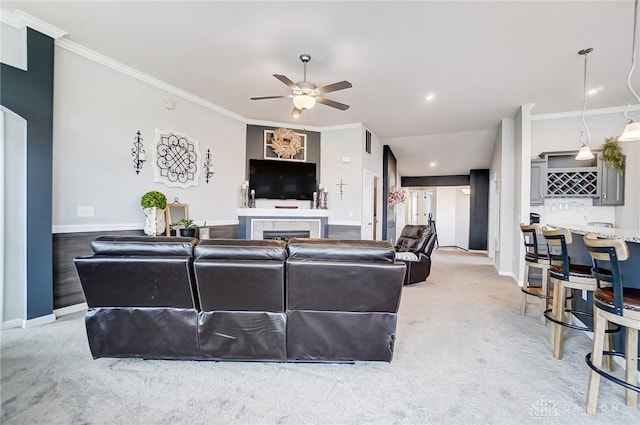 living room featuring ornamental molding, indoor bar, light carpet, and ceiling fan