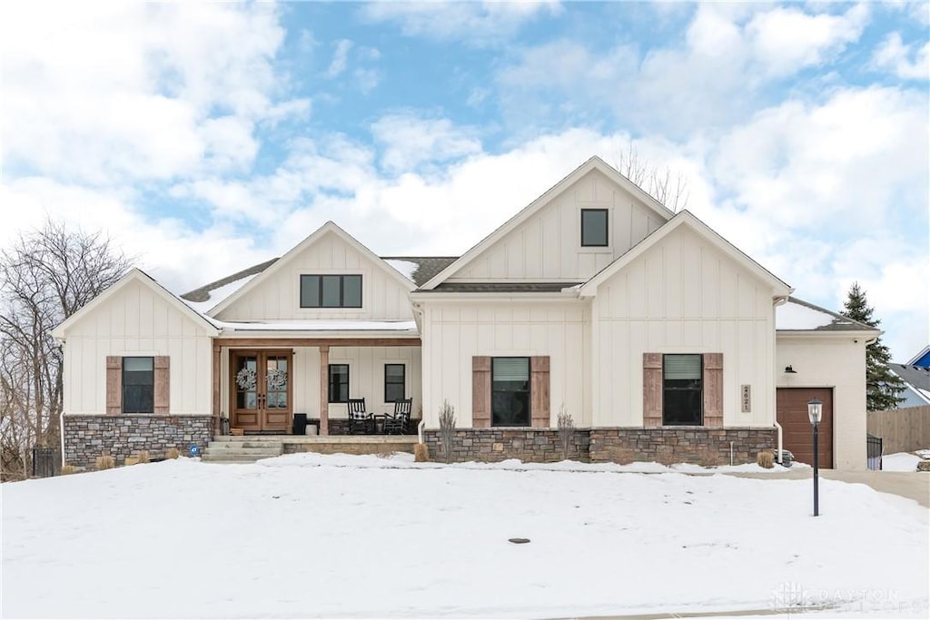 modern inspired farmhouse featuring a garage and covered porch