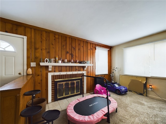 living room with a brick fireplace and wooden walls