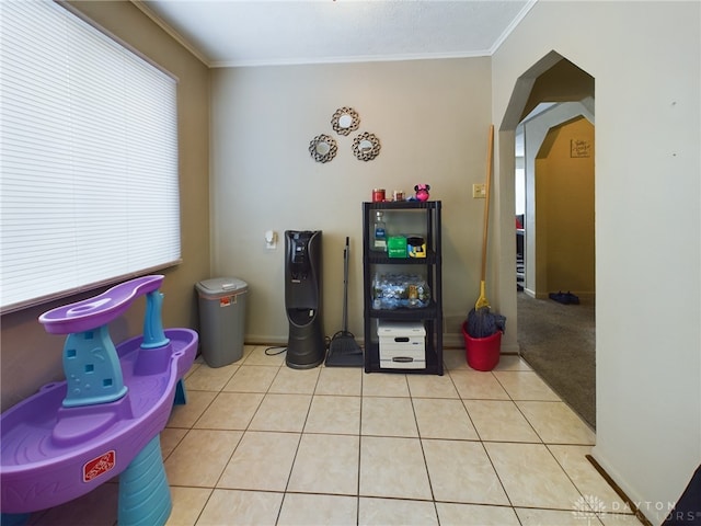 interior space with a healthy amount of sunlight, ornamental molding, and light tile patterned floors