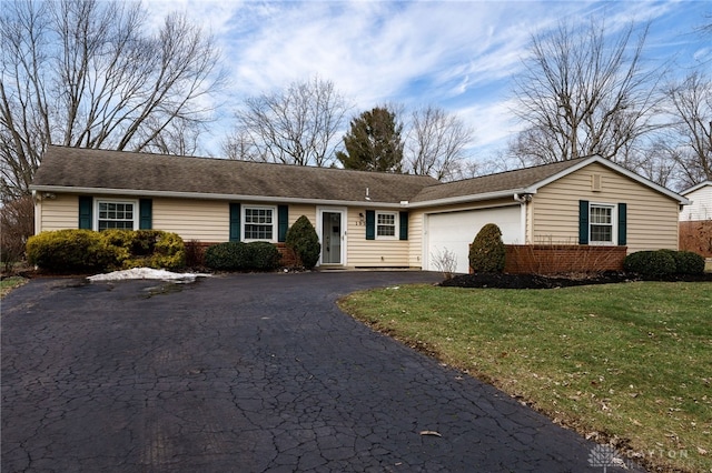 ranch-style house featuring a garage and a front yard