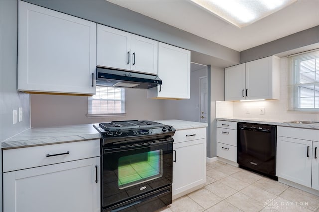 kitchen featuring light tile patterned flooring, white cabinets, a healthy amount of sunlight, and black appliances