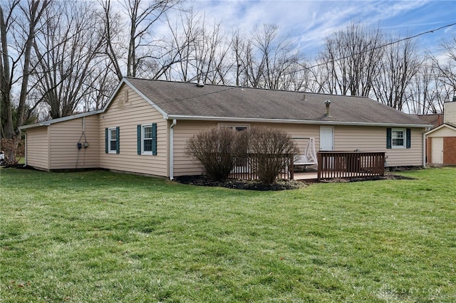 rear view of property featuring a lawn and a deck