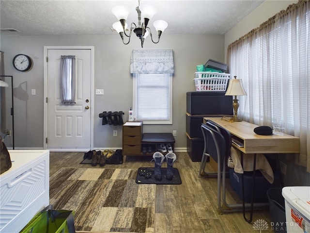 office with dark hardwood / wood-style flooring, plenty of natural light, a textured ceiling, and an inviting chandelier