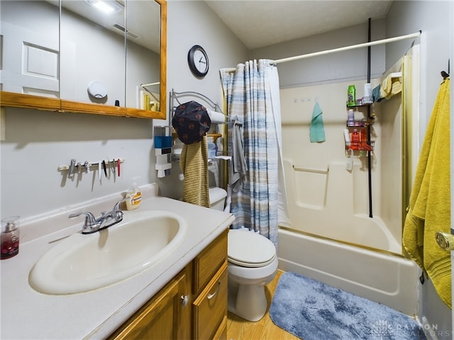 full bathroom featuring vanity, hardwood / wood-style floors, shower / tub combo with curtain, and toilet