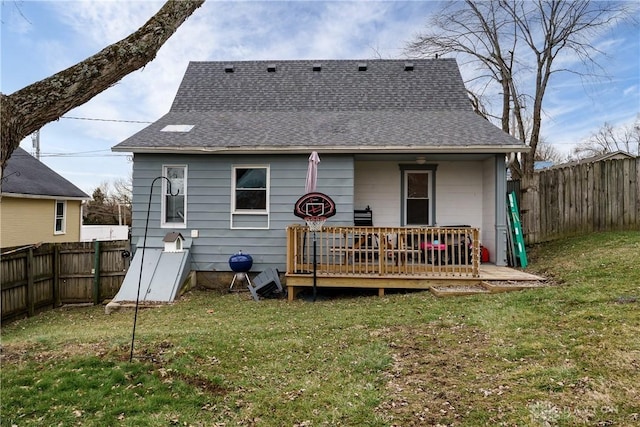 back of house with a deck and a lawn