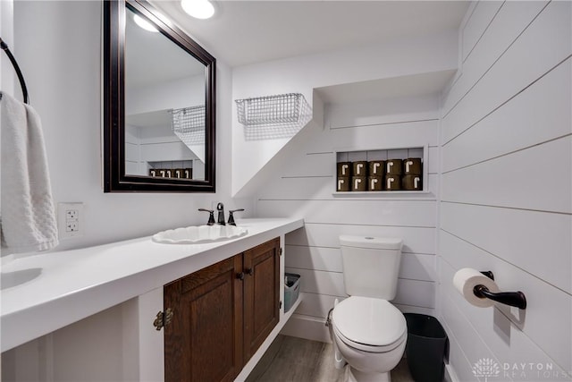 bathroom with vanity, toilet, and hardwood / wood-style floors