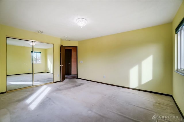 unfurnished bedroom with a closet and light carpet