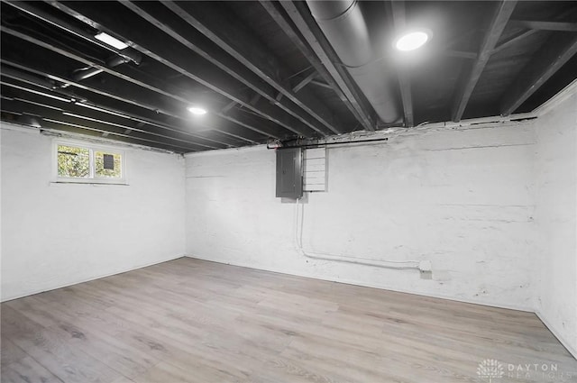 basement featuring hardwood / wood-style flooring and electric panel