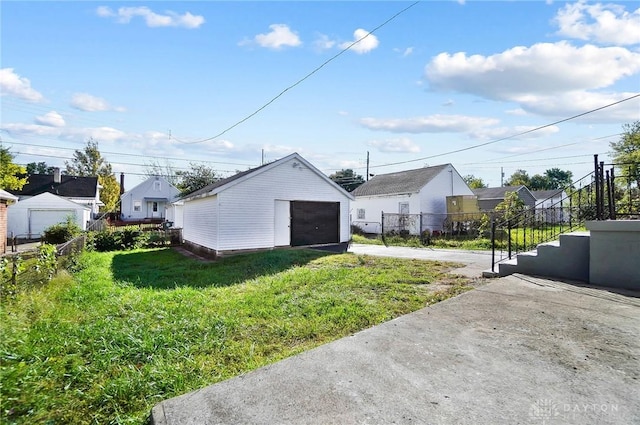 exterior space featuring an outbuilding, a garage, and a lawn