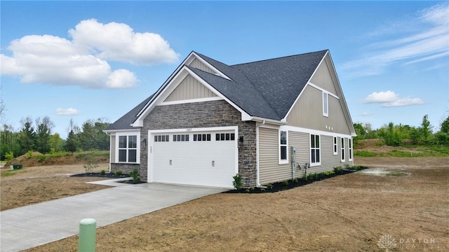 1507 Kingsgate, Springfield, OH 45502 - view of front of home with stone siding, concrete driveway, an attached garage, a shingled roof, and board and batten siding