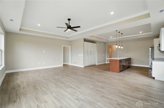 1507 Kingsgate, Springfield, OH 45502 - unfurnished living room featuring a tray ceiling, ceiling fan, light wood finished floors, ornamental molding, and a sink