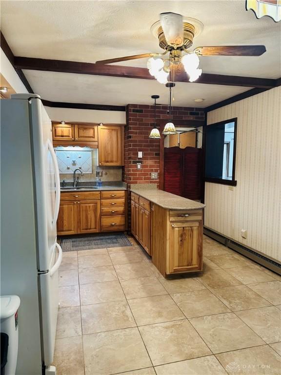 kitchen with sink, decorative light fixtures, white refrigerator, kitchen peninsula, and beam ceiling