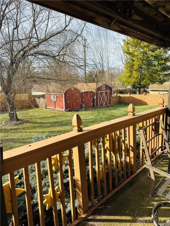 wooden deck with a yard and a storage shed