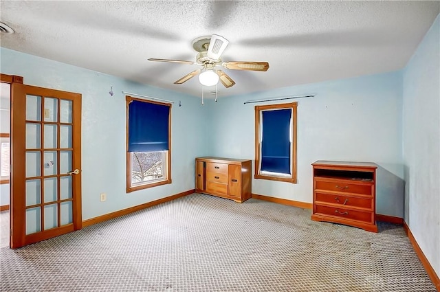 spare room with ceiling fan, a textured ceiling, and carpet flooring