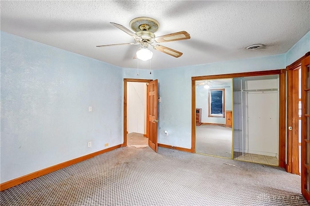 unfurnished bedroom with ceiling fan, light colored carpet, a textured ceiling, and a closet