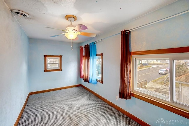 carpeted spare room with ceiling fan