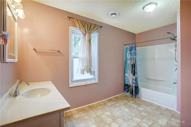 bathroom featuring shower / tub combo with curtain, vanity, and a textured ceiling