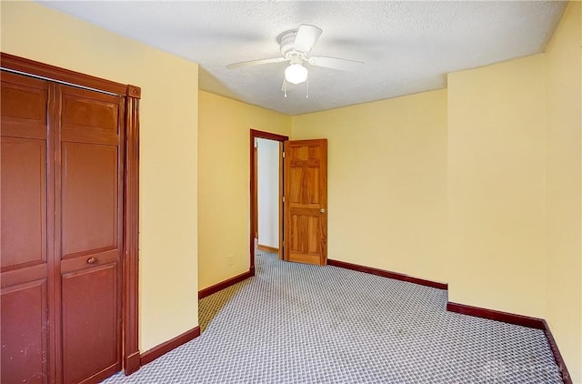 unfurnished bedroom with ceiling fan, light colored carpet, and a textured ceiling