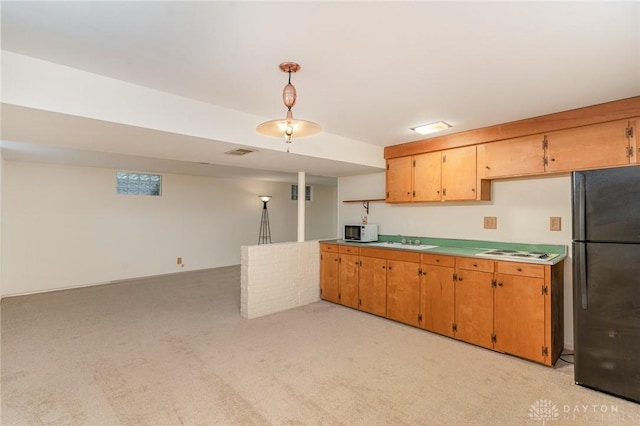 kitchen with decorative light fixtures, sink, white appliances, and light colored carpet