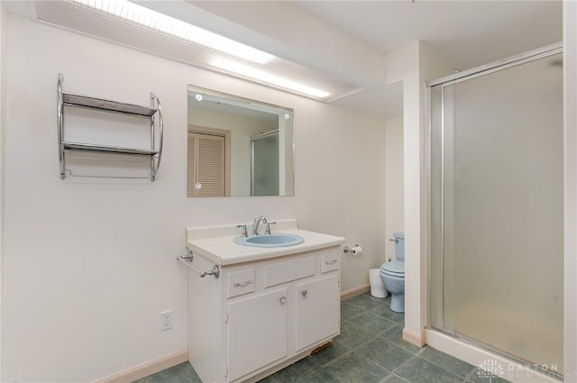 bathroom with vanity, a shower with shower door, and toilet