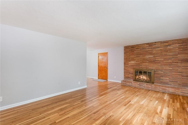 unfurnished living room with a fireplace and light hardwood / wood-style flooring