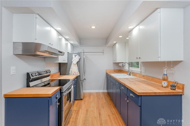 kitchen featuring wood counters, appliances with stainless steel finishes, sink, and white cabinets