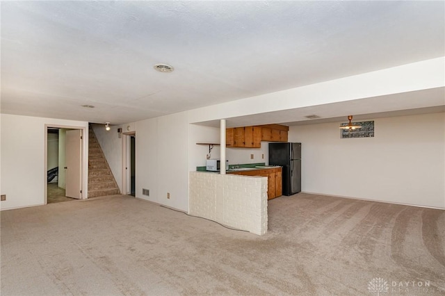 unfurnished living room featuring light colored carpet