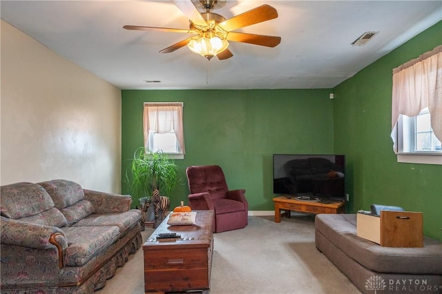 carpeted living room with ceiling fan