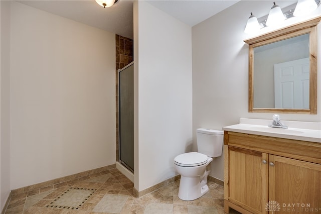 bathroom with vanity, toilet, and a shower with shower door