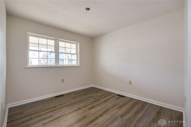 empty room with dark hardwood / wood-style flooring