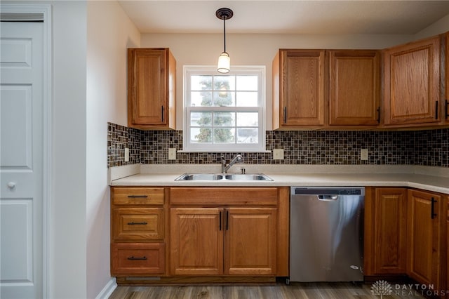 kitchen featuring sink, hardwood / wood-style flooring, stainless steel dishwasher, pendant lighting, and backsplash