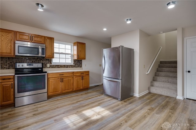 kitchen with tasteful backsplash, light hardwood / wood-style flooring, and stainless steel appliances