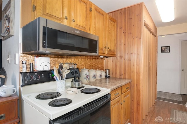 kitchen with dark hardwood / wood-style flooring, backsplash, and range with electric cooktop