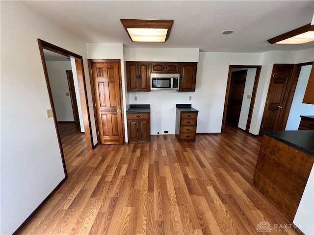 kitchen featuring dark brown cabinetry and dark hardwood / wood-style floors