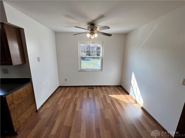 unfurnished dining area featuring wood-type flooring and ceiling fan