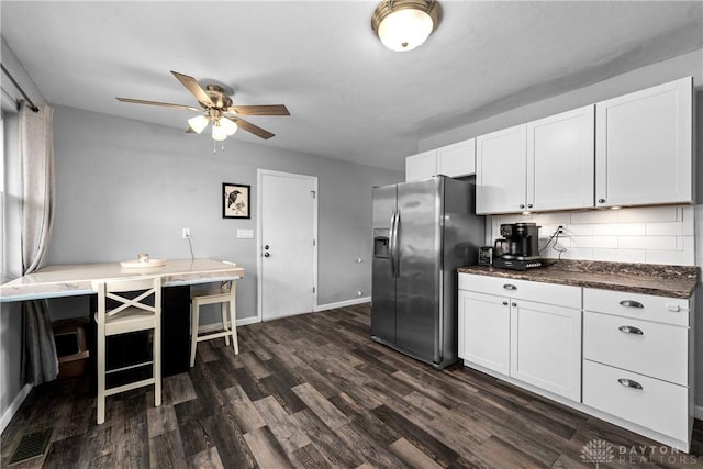 kitchen with white cabinets, stainless steel fridge, decorative backsplash, ceiling fan, and dark wood-type flooring