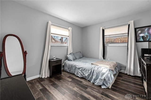 bedroom featuring multiple windows and dark hardwood / wood-style floors