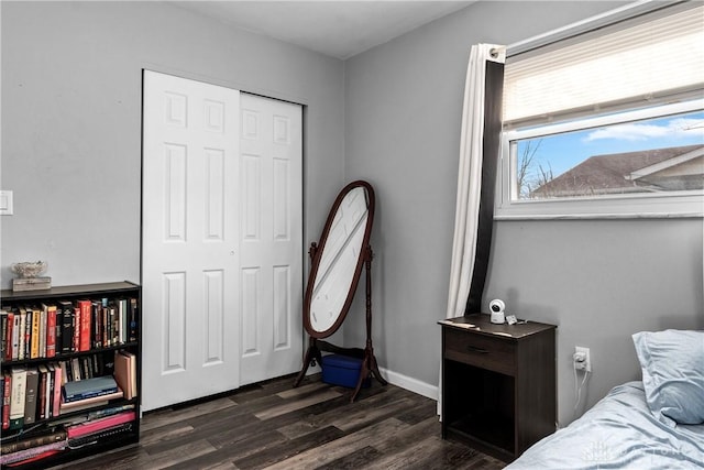 bedroom with dark wood-type flooring and a closet