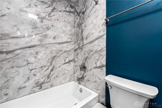 bathroom with tiled shower / bath combo and toilet