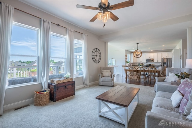 living room with ceiling fan and light colored carpet