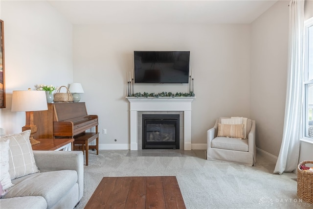 living room with a tiled fireplace and light colored carpet