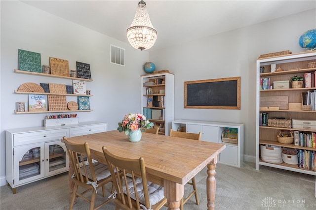 carpeted dining space featuring a notable chandelier