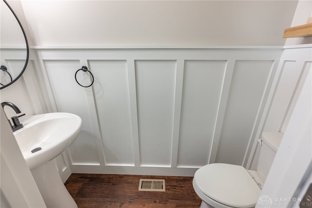 bathroom featuring hardwood / wood-style flooring and toilet