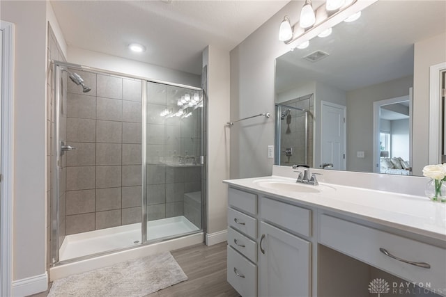 bathroom with vanity, an enclosed shower, and wood-type flooring